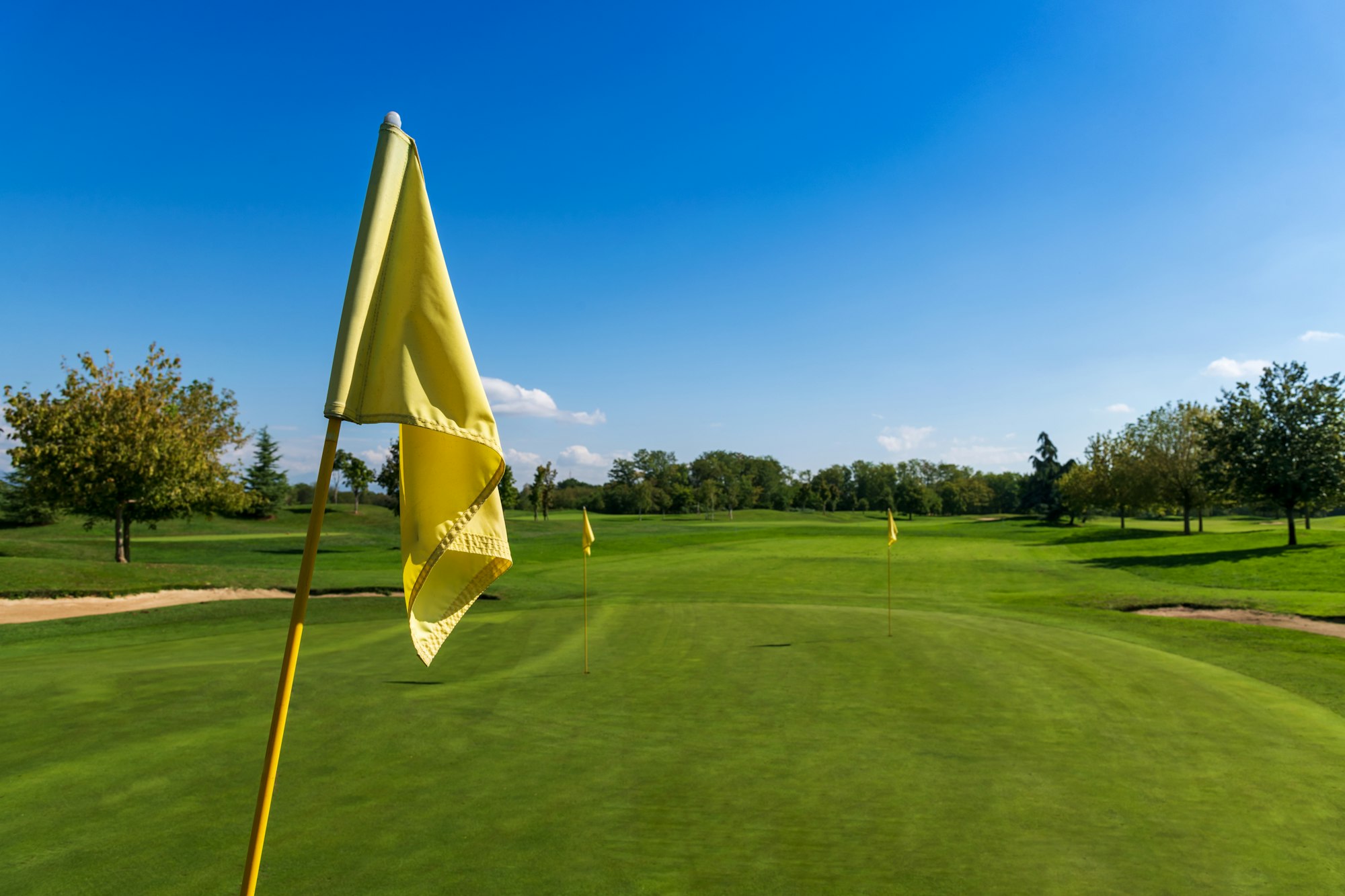 Yellow flag on green golf course